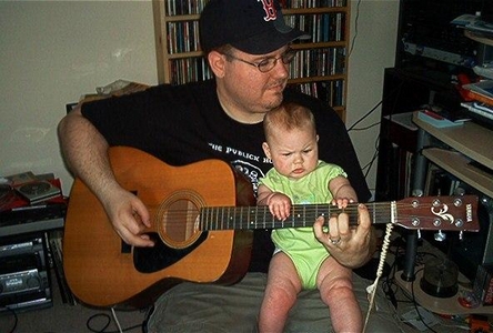 Daddy playing guitar with a baby girl