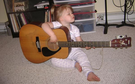 Little Girl Playing an Acoustic Guitar